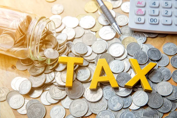 TAX Concept.Word impuesto poner en monedas con pluma y calculadora en la ficha — Foto de Stock