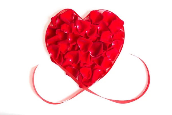 Καρδιά γίνεται από κόκκινο αυξήθηκε πέταλα και απομονωμένες κόκκινη κορδέλα σε λευκό — Φωτογραφία Αρχείου