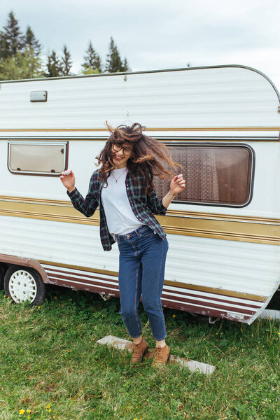 woman dancing near travel trailer