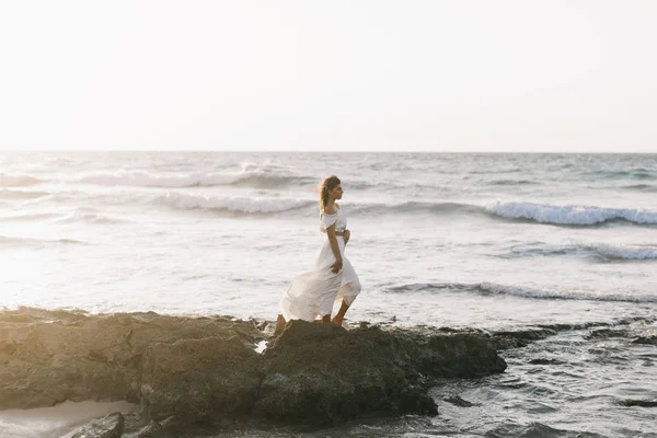 güzel kız gün batımında sahilde yürüyüş