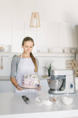 Işık mutfakta dekore edilmiş ev yapımı kek ile genç pudra