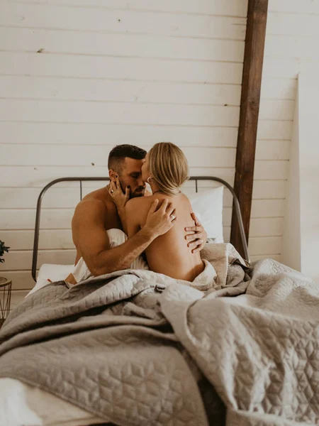 Güzel bir çift yatakta öpüşüyor.