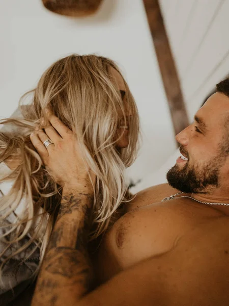 Güzel bir çift yatakta öpüşüyor.