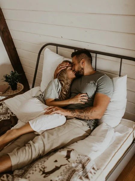 Güzel bir çift yatakta öpüşüyor.