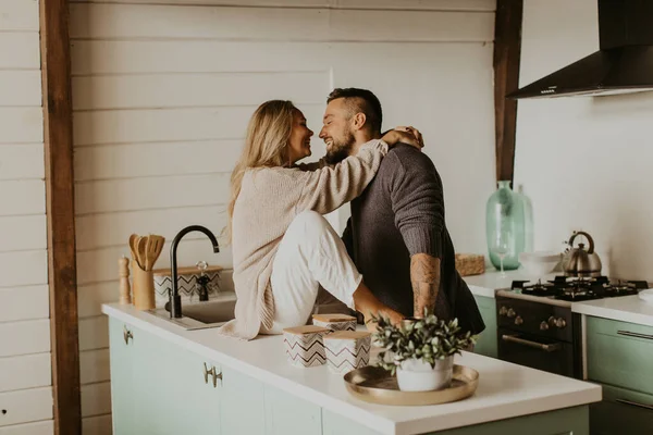 Beautiful couple in love kisses in the kitchen