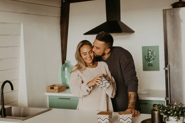 Beautiful couple in love kisses in the kitchen