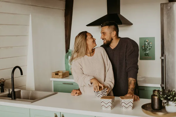 Beautiful couple in love kisses in the kitchen