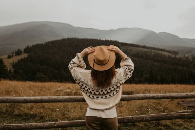Dağlarda dinlenen kız, manzaranın tadını çıkarıyor.