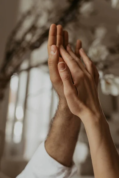 Hands of man and woman gently touch each other