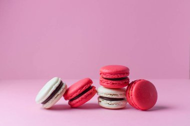 Rengarenk güzel tatlılar. Pembe arka planda Fransız kurabiyeleri.