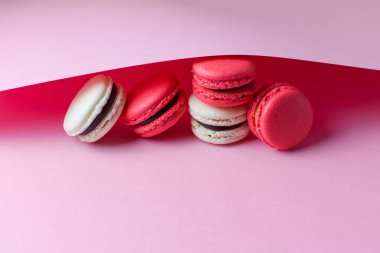 Rengarenk güzel tatlılar. Pembe arka planda Fransız kurabiyeleri.