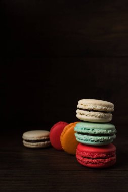 Rengarenk güzel tatlılar. Koyu renk ahşap arka planda Fransız kurabiyeleri.