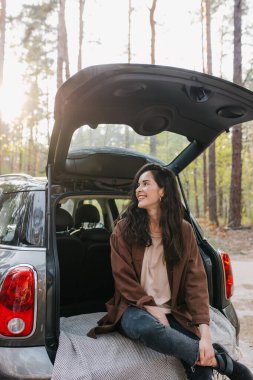 Genç ve güzel bir kız bir arabanın bagajında dinleniyor.