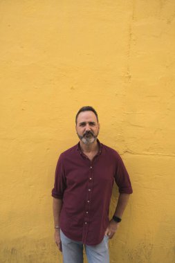 Sarı duvarda gri sakallı adam