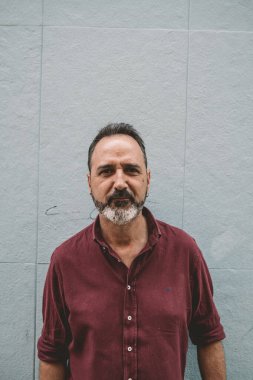 Gri duvarda gri sakallı adam