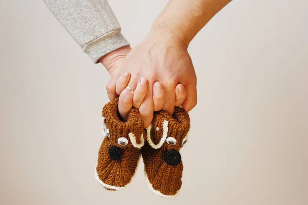 Happy young parents hold in their hands baby shoes of future chi — Stock Photo, Image