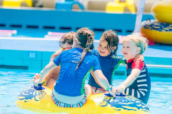 Young children having fun in water pool — Stock Photo, Image