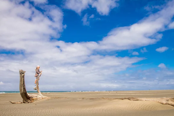 Jovem sozinho criança menina siiting no tronco de madeira seca — Fotografia de Stock