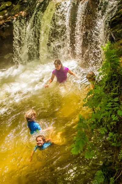 Family swimming in thermal river in forest — Stock Photo, Image