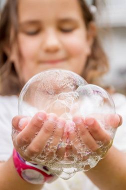 sabun köpüğü ile oynayan mutlu çocuk 