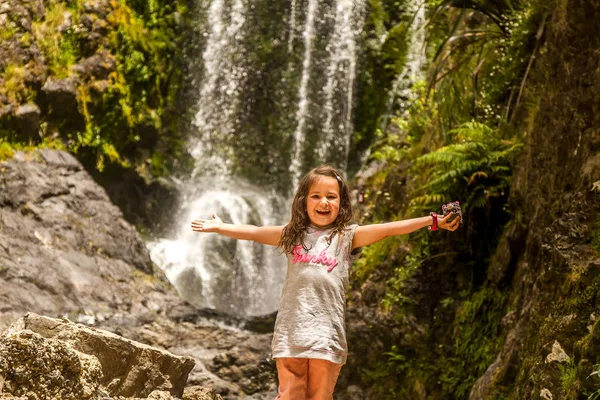 Chica cerca de hermosa caída de agua en el bosque —  Fotos de Stock