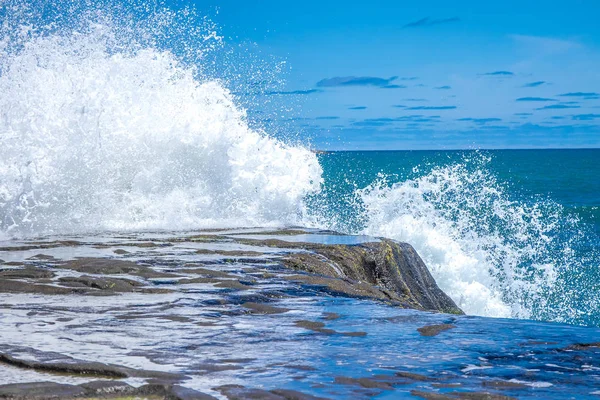 De golven breken op een stenig strand — Stockfoto