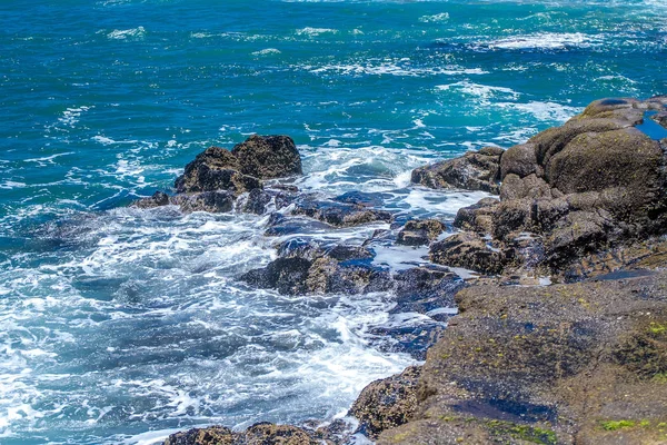 Vågorna bryter på en stenig strand — Stockfoto