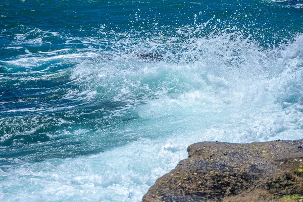 Le onde che si infrangono su una spiaggia rocciosa — Foto Stock