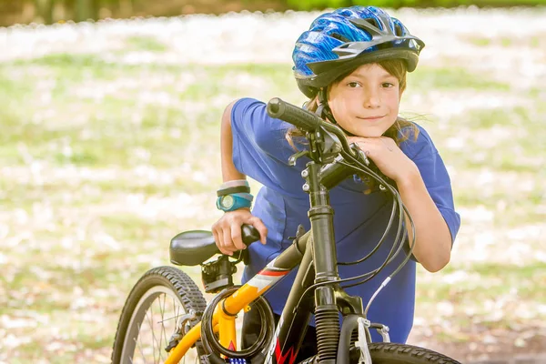 Niño montando una bicicleta en el parque natural —  Fotos de Stock