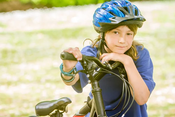 Niño montando una bicicleta en el parque natural —  Fotos de Stock