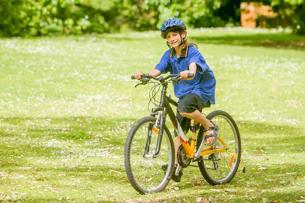 Boy riding a bicycle on natural park — Stock Photo, Image
