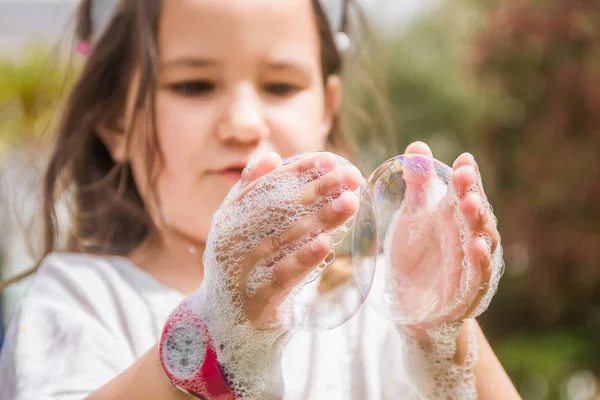 Šťastné dítě hraje s mýdlové bubliny — Stock fotografie