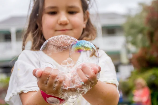 Счастливый ребенок, играющий с мыльными пузырями — стоковое фото