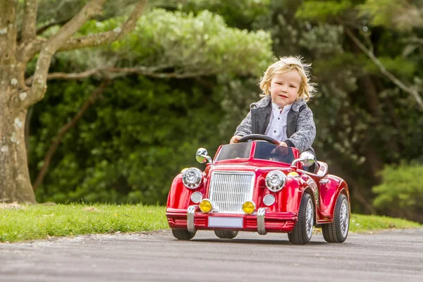 Детский мальчик за рулем игрушечной машины — стоковое фото