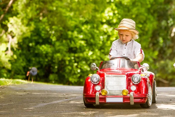 Детский мальчик за рулем игрушечной машины — стоковое фото