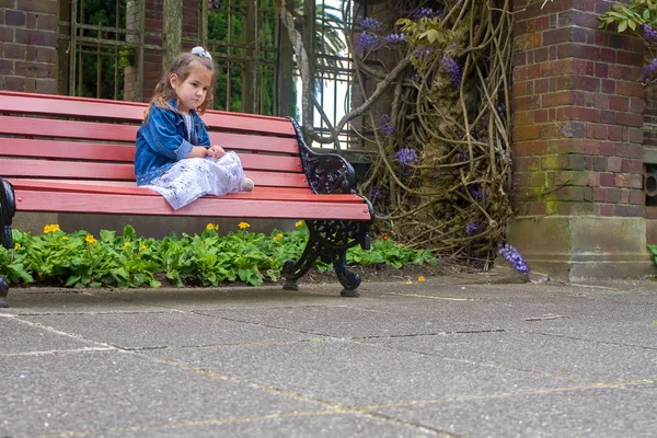 Dítě dívka sedí na lavičce — Stock fotografie