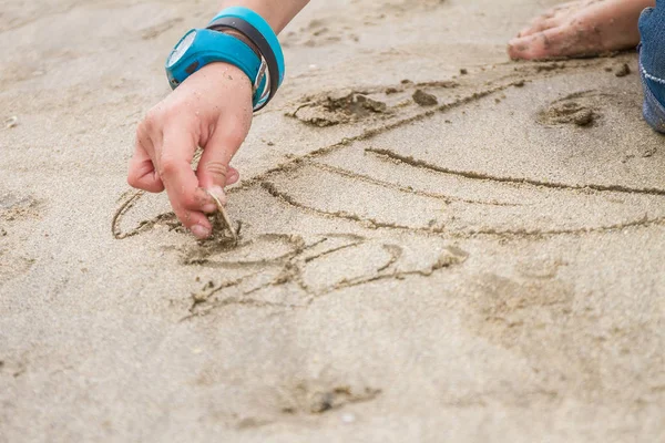 Junge zeichnet im Sand — Stockfoto