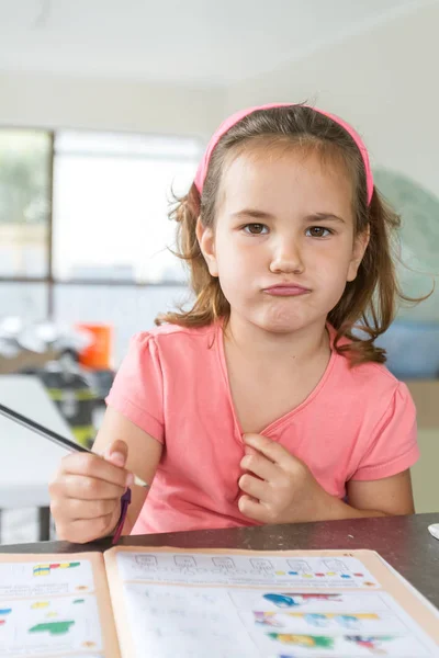 Young child girl writing in notebook — Stock Photo, Image