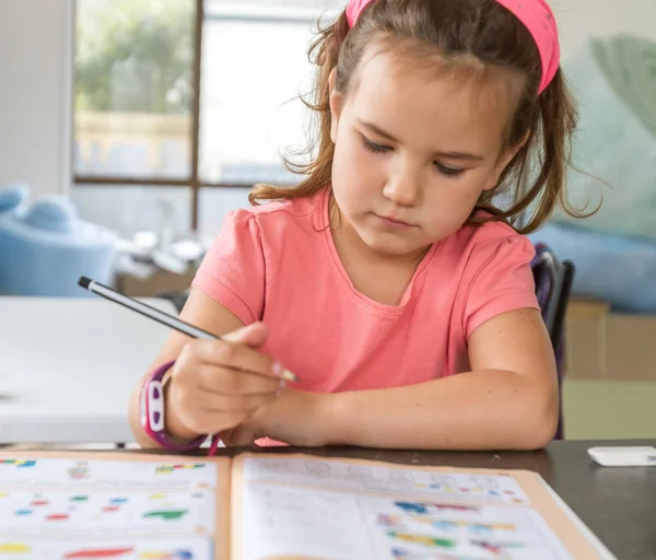 Young child girl writing in notebook — Stock Photo, Image