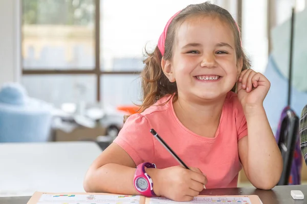 Young child girl writing in notebook — Stock Photo, Image