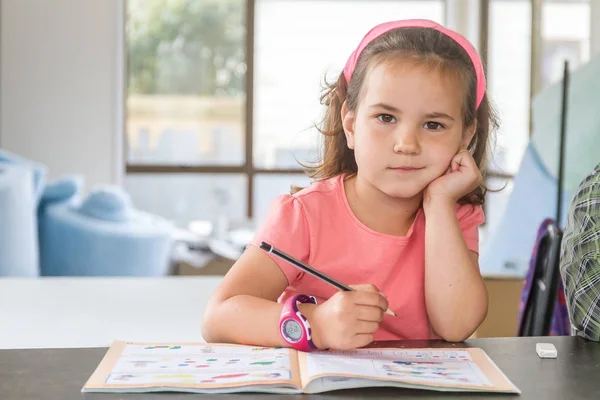 Malé dítě dívka psaní v poznámkovém bloku — Stock fotografie