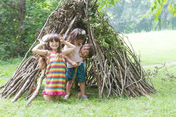 Enfants jouant à côté de bâton en bois maison — Photo