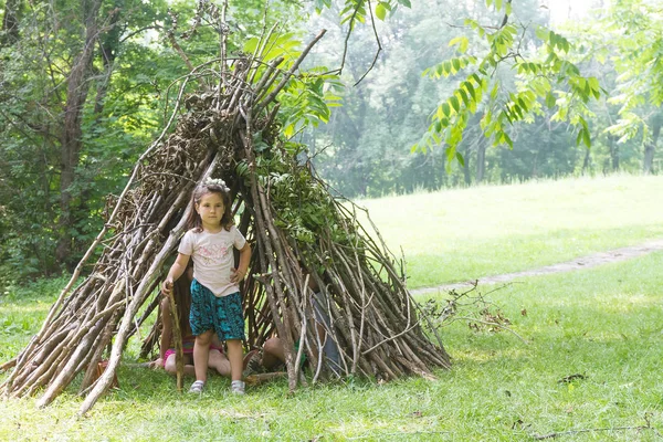 Děti hrají vedle domu dřevěnou hůl — Stock fotografie