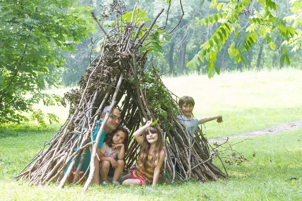 Kinderen spelen naast houten stok huis — Stockfoto