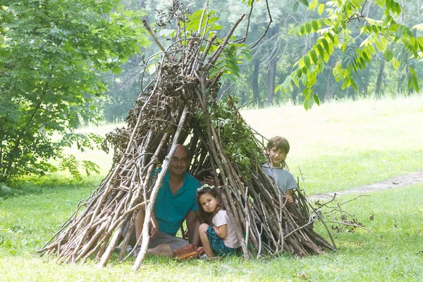 Kinderen spelen naast houten stok huis — Stockfoto