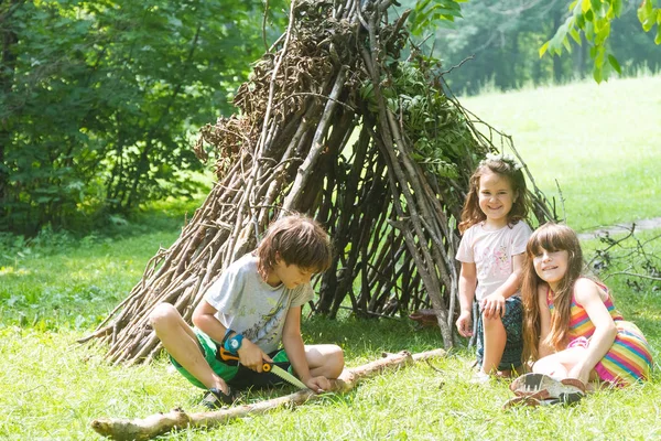 Enfants jouant à côté de bâton en bois maison — Photo