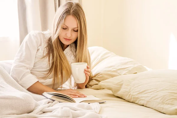 Молодая женщина сидит в постели — стоковое фото