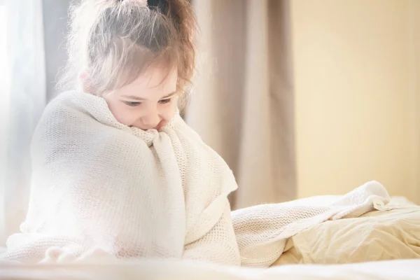 Retrato interior de menina envolto em cobertor — Fotografia de Stock