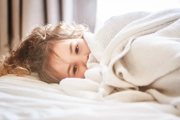 Retrato interior de menina envolto em cobertor — Fotografia de Stock