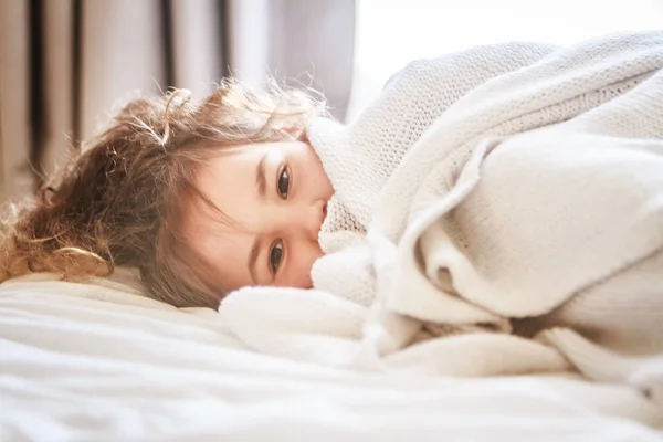 Indoor portrait of young child girl wrapped in blanket — Stock Photo, Image